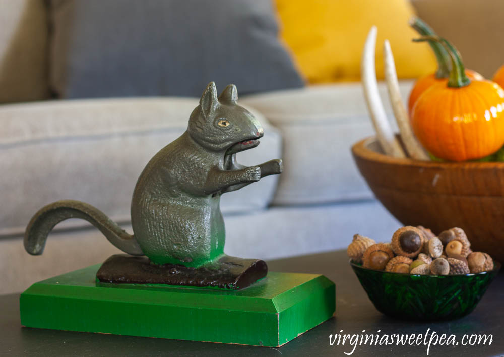 Vintage squirrel nutcracker on a coffee table decorated for fall with vintage.