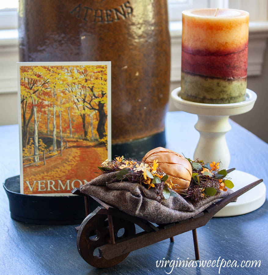 Vermont themed fall vignette - Vermont postcard with a Byer's wheelbarrow and a fall candle.