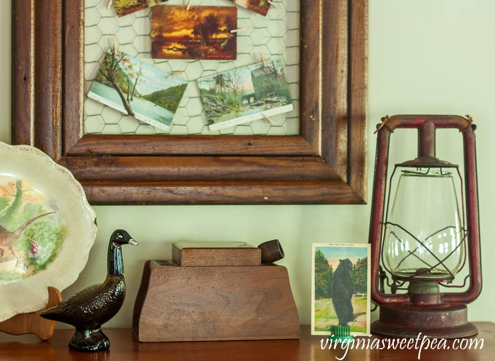 Fall Vignette with an Avon Goose Bottle, vintage pipe and tobacco box, antique lantern, and a vintage bear postcard.