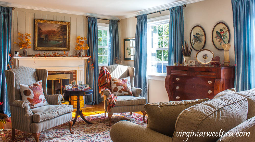 A living room is decorated for Thanksgiving with mostly vintage decor.