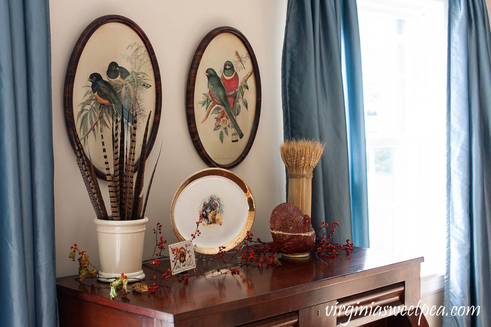 Thanksgiving Decor with Vintage - An antique chest is decorated with a vintage turkey platter, crock filled with pheasant feathers, a vintage Thanksgiving postcard, a wheat sheaf, and a vintage turkey lidded dish.