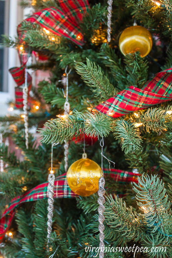 Christmas tree decorated with 1970's satin yellow and red balls, plaid ribbon, and glittered icicles.