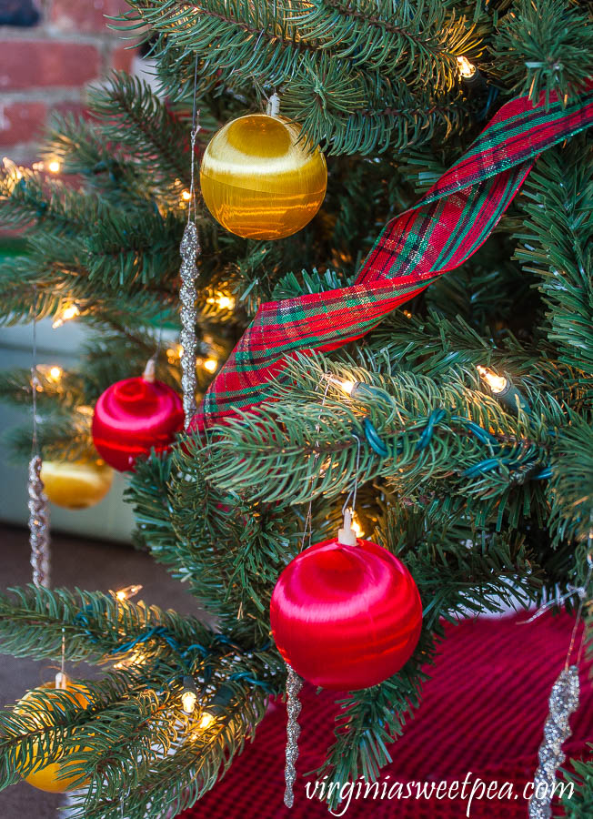 Christmas tree decorated with plaid ribbon, red and gold 1970's satin covered balls, and glittered icicles.