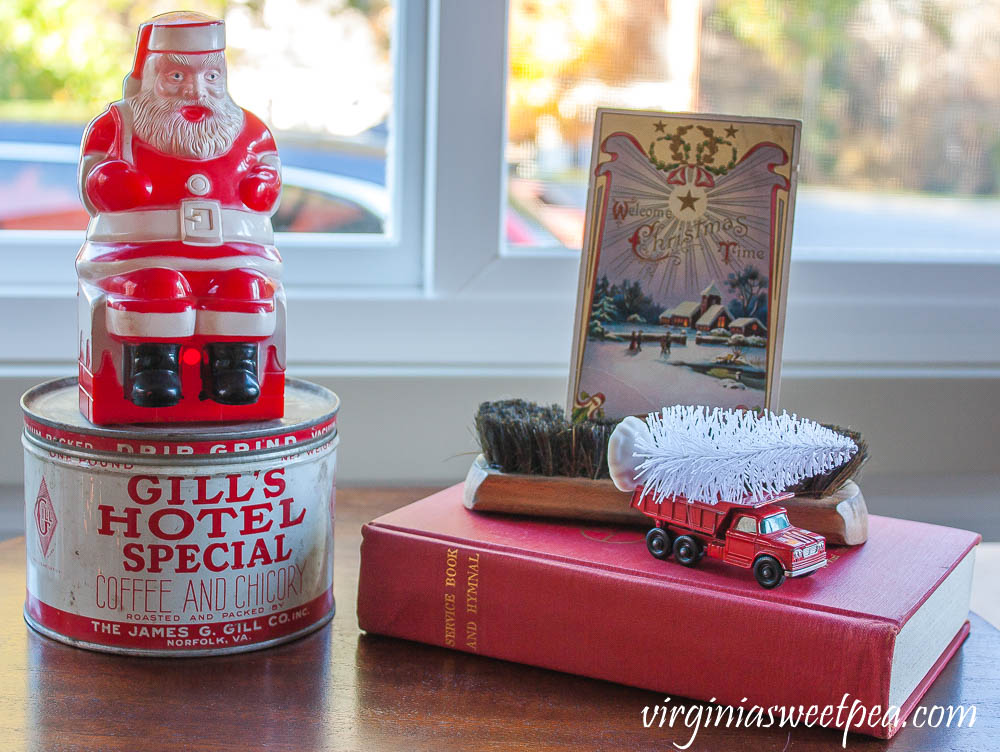 Vintage Santa, vintage Gill's Hotel Special coffee can, 1910 Christmas postcard, vintage shoe brush, vintage Matchbox truck and a 1958 hymnal.