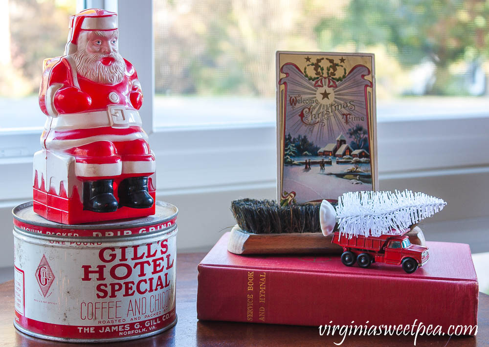 Vintage Santa, vintage Gill's Hotel Special coffee can, 1910 Christmas postcard, vintage shoe brush, vintage Matchbox truck and a 1958 hymnal.