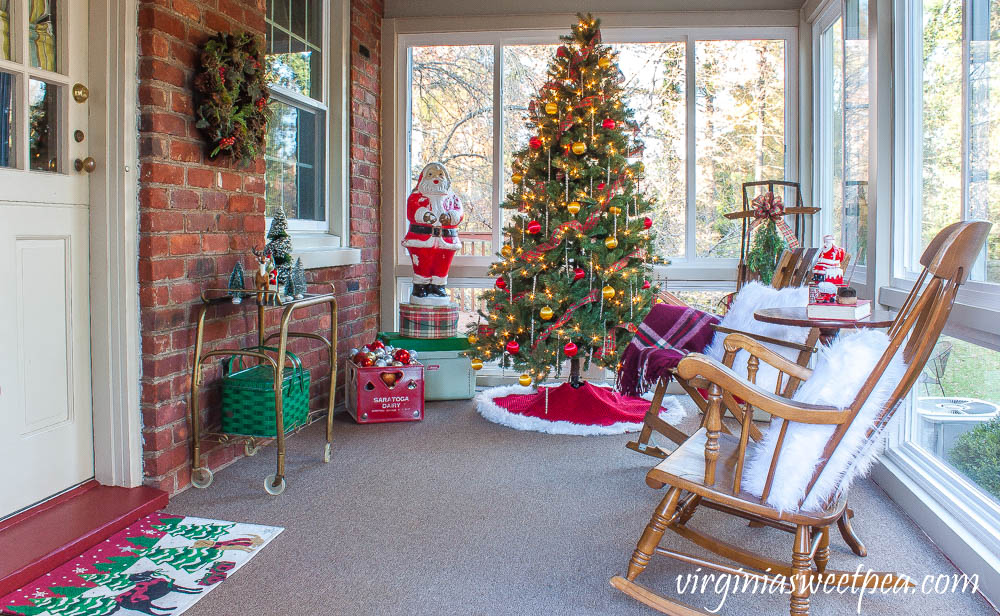 A Very Vintage Christmas on the Porch - An enclosed porch is decorated for Christmas with a vintage Santa blow mold, vintage coolers, a vintage sled, and more.