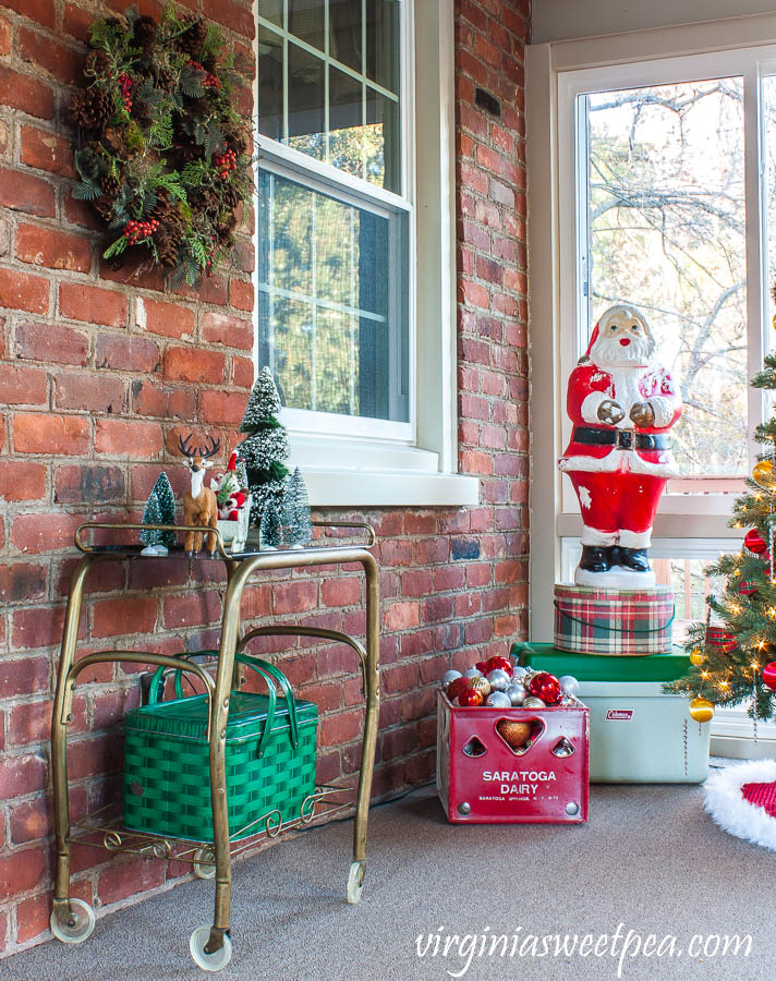 A Very Vintage Christmas on the porch - Vintage tv stand decorated for Christmas, vintage Santa blow mold, vintage Saratoga Dairy milk crate, and a vintage Coleman cooler.