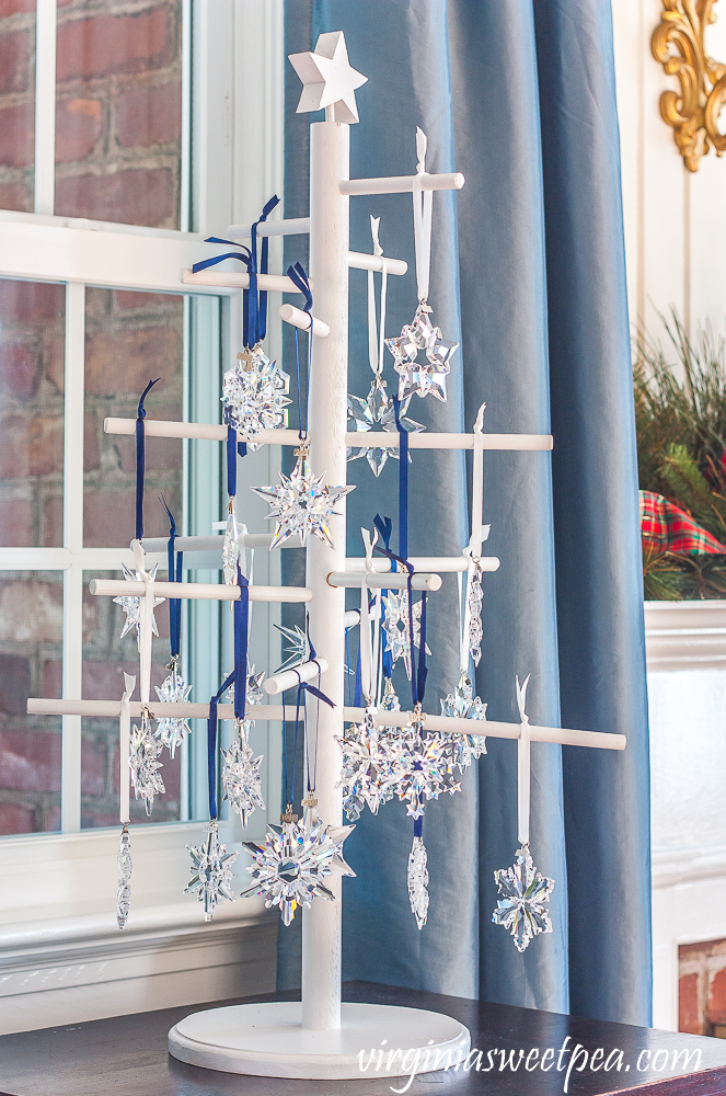 A wooden tree displaying Swarovski snowflake Christmas ornaments dated from 1993 - 2019