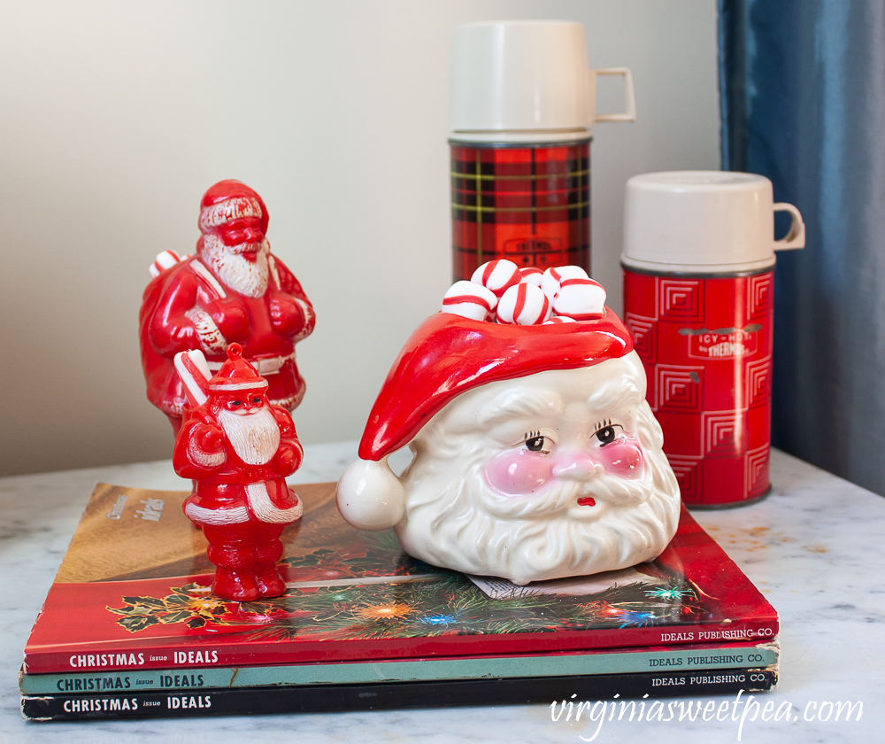 Vintage Christmas Ideals books, vintage plastic Santa candy holders, vintage Santa Christmas mugs, vintage thermoses