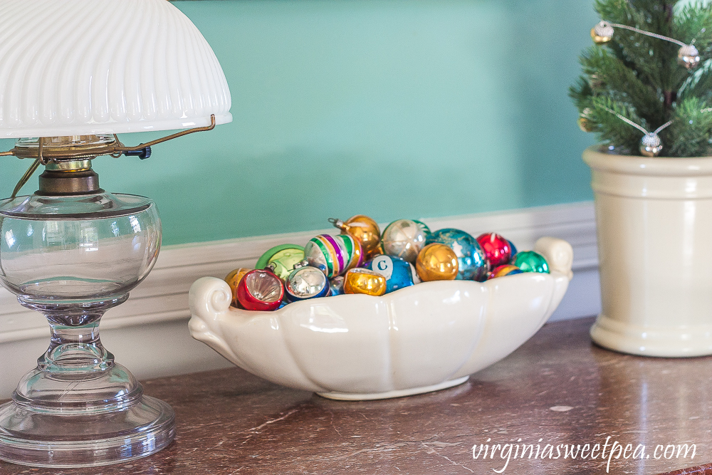 A Very Vintage Christmas in the Dining Room - Antique chest decorated for Christmas with vintage ornaments in a McCoy dish.