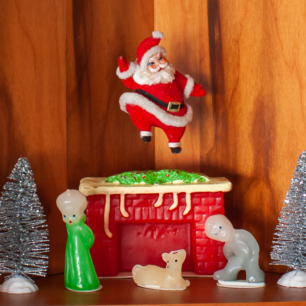 Kitchen shelf decorated with vintage look candles from The Vermont Country Store, a vintage Santa, and bottlebrush trees.