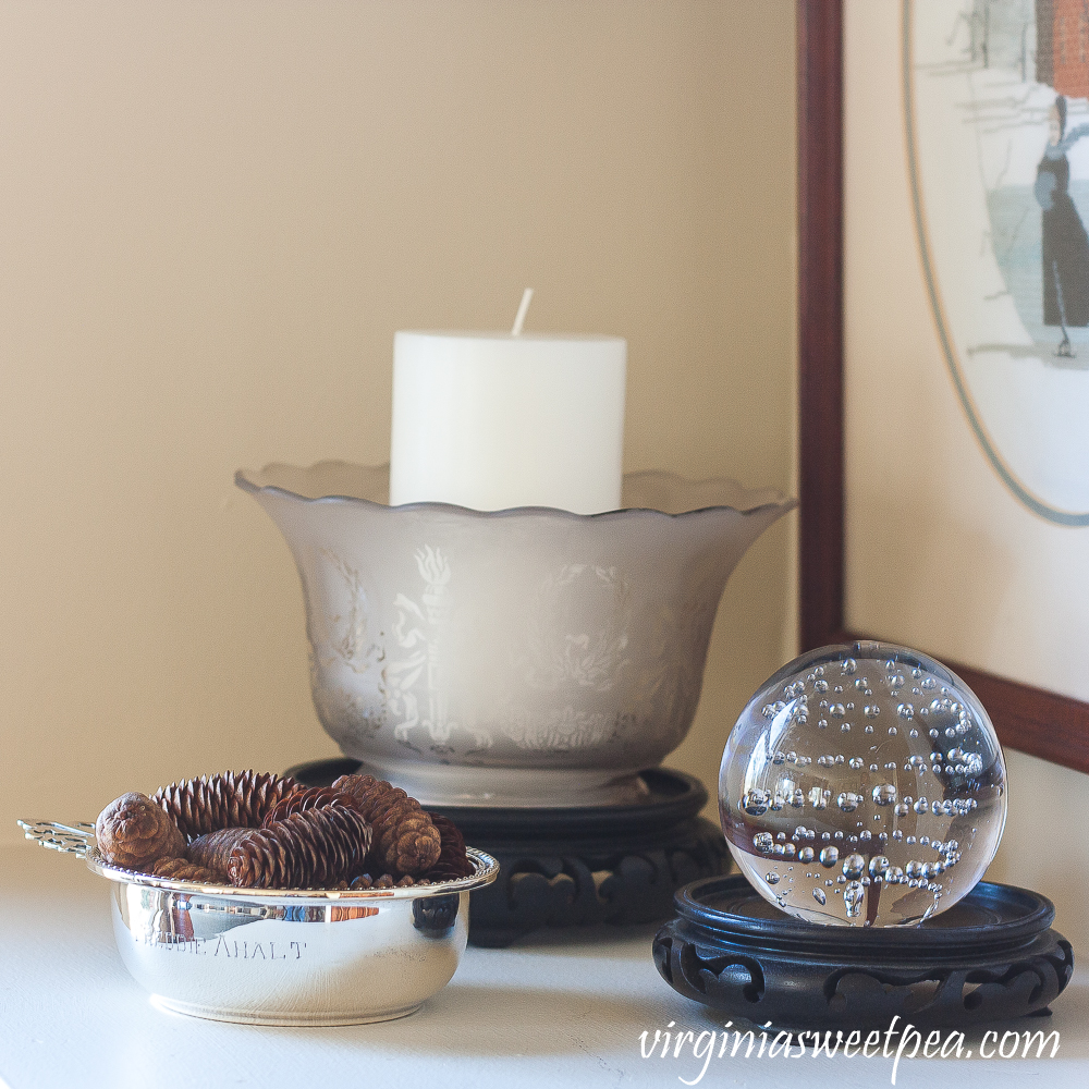 Silver child's porridge bowl, antique glass lamp shade, glass ball with bubbles in the glass.