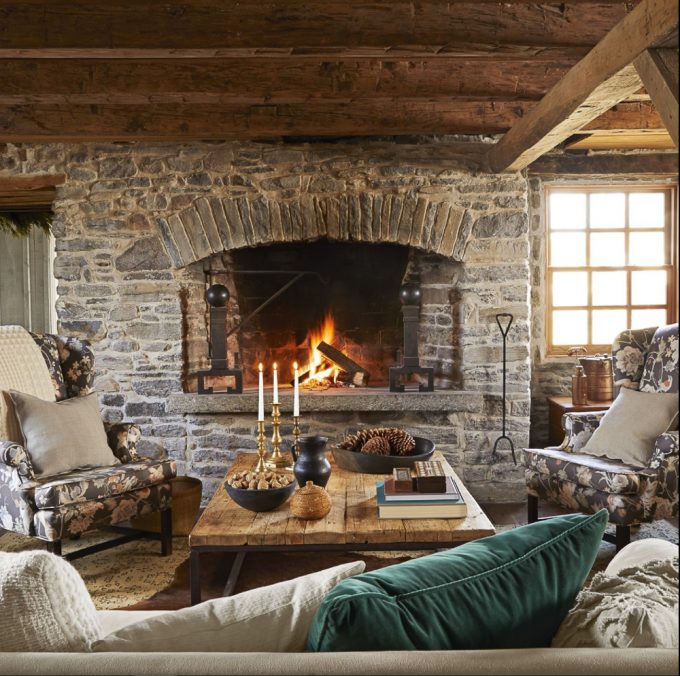 Rock fireplace in a cabin with a wood plank coffee table decorated for winter