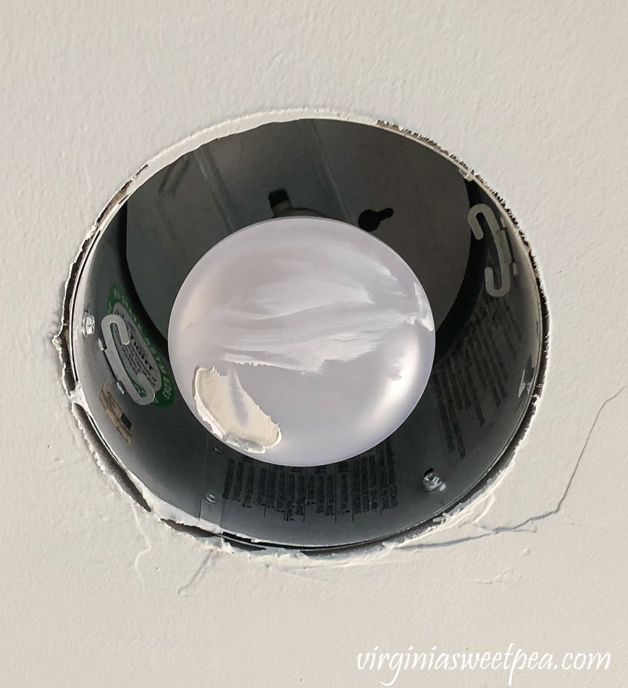 Can light bulb with ceiling paint and drywall mud on it.