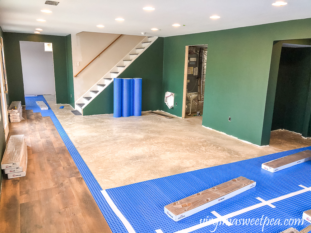 Basement with walls Painted with Sherwin Williams Emerald Paint in Rock Garden and floor installation with Mohawk Crest Loft in Prairie Oak