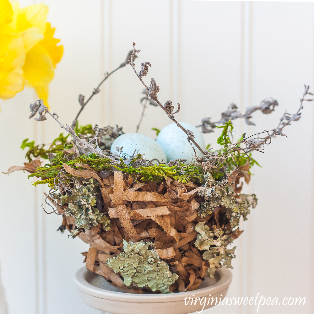 Spring nest made with a paper bag and embellished with moss, twigs, and lichen.