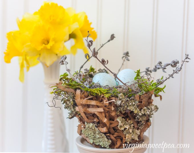 Spring nest made with a paper bag and embellished with moss, twigs, and lichen.