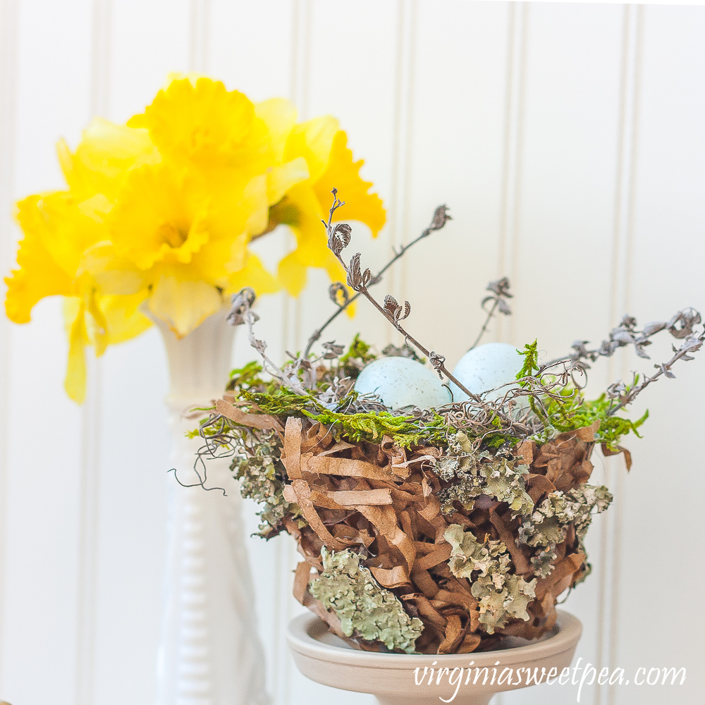 Spring nest made with a paper bag and embellished with moss, twigs, and lichen.