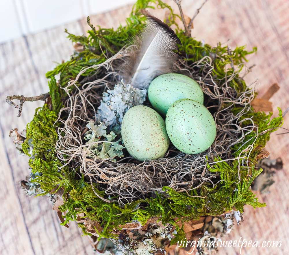 Spring nest made with a paper bag and embellished with moss, twigs, and lichen.