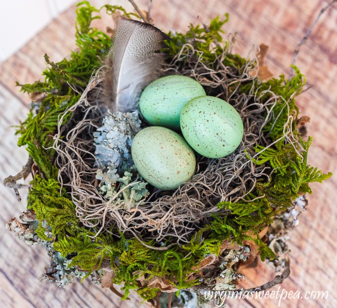 Spring nest made with a paper bag and embellished with moss, twigs, and lichen.