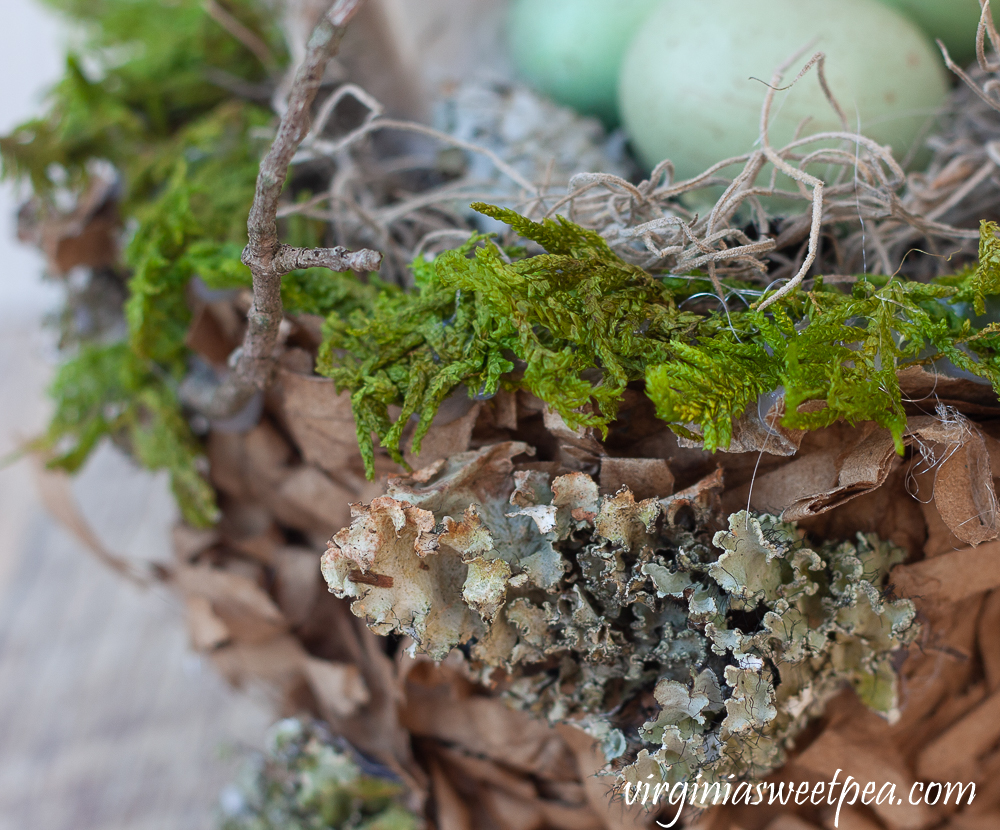 Spring nest made with a paper bag and embellished with moss, twigs, and lichen.