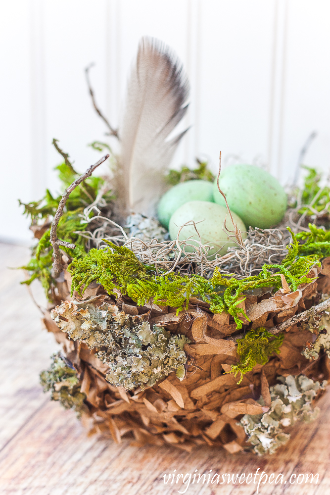 Spring nest made with a paper bag and embellished with moss, twigs, and lichen.