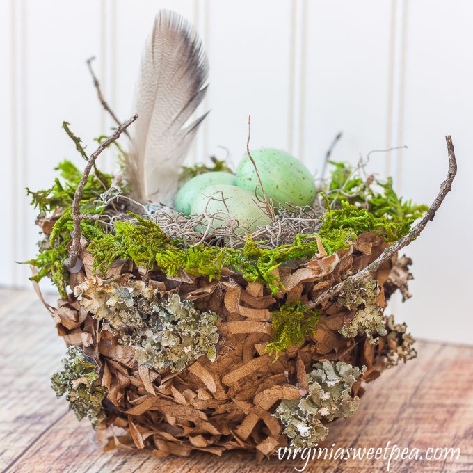 Spring nest made with a paper bag and embellished with moss, twigs, and lichen.