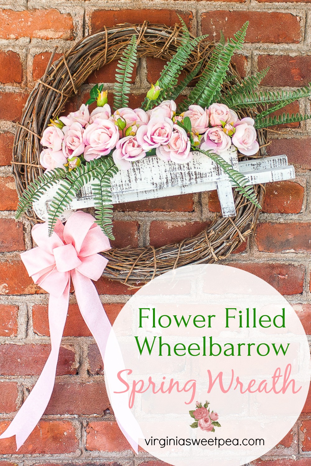 Spring wreath with a rose filled wheelbarrow and a pink bow