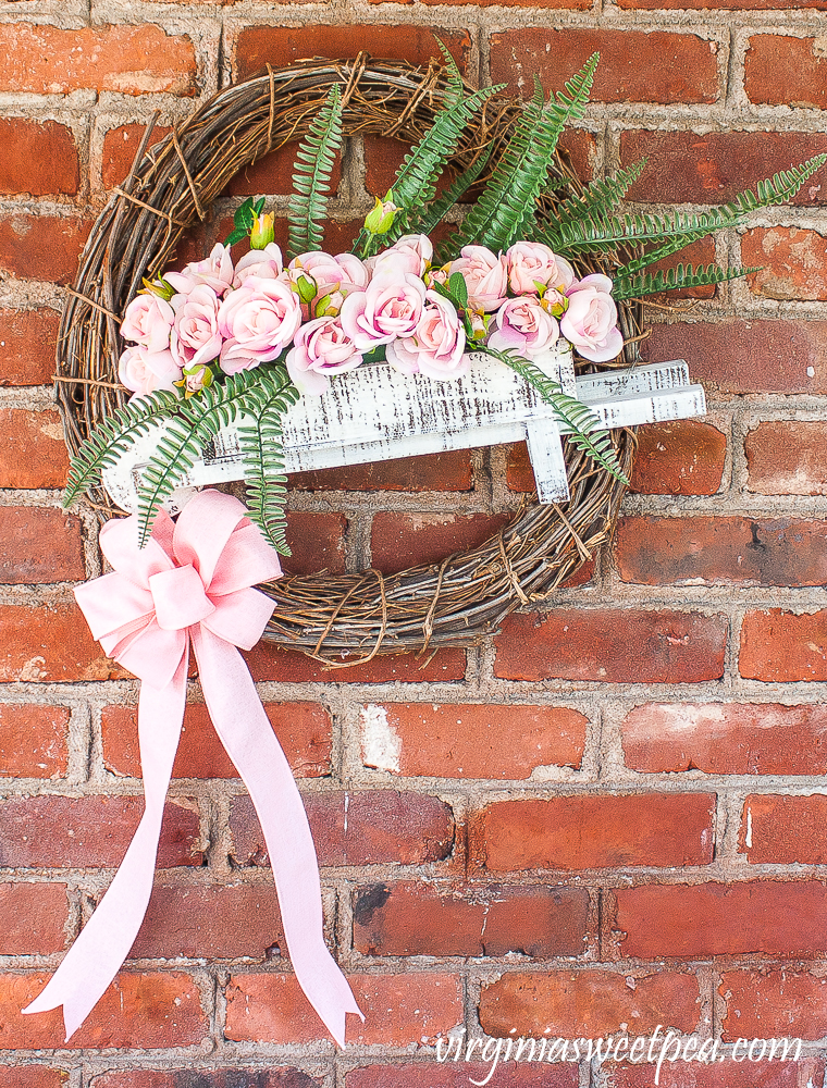 Spring wreath with a wheelbarrow filled with flowers