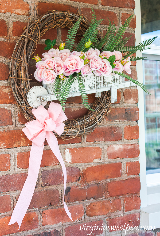 Spring wreath with a wheelbarrow filled with flowers