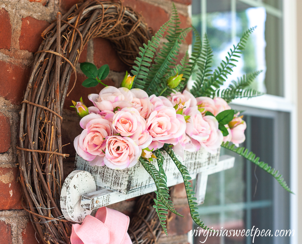 Spring wreath with a wheelbarrow filled with flowers
