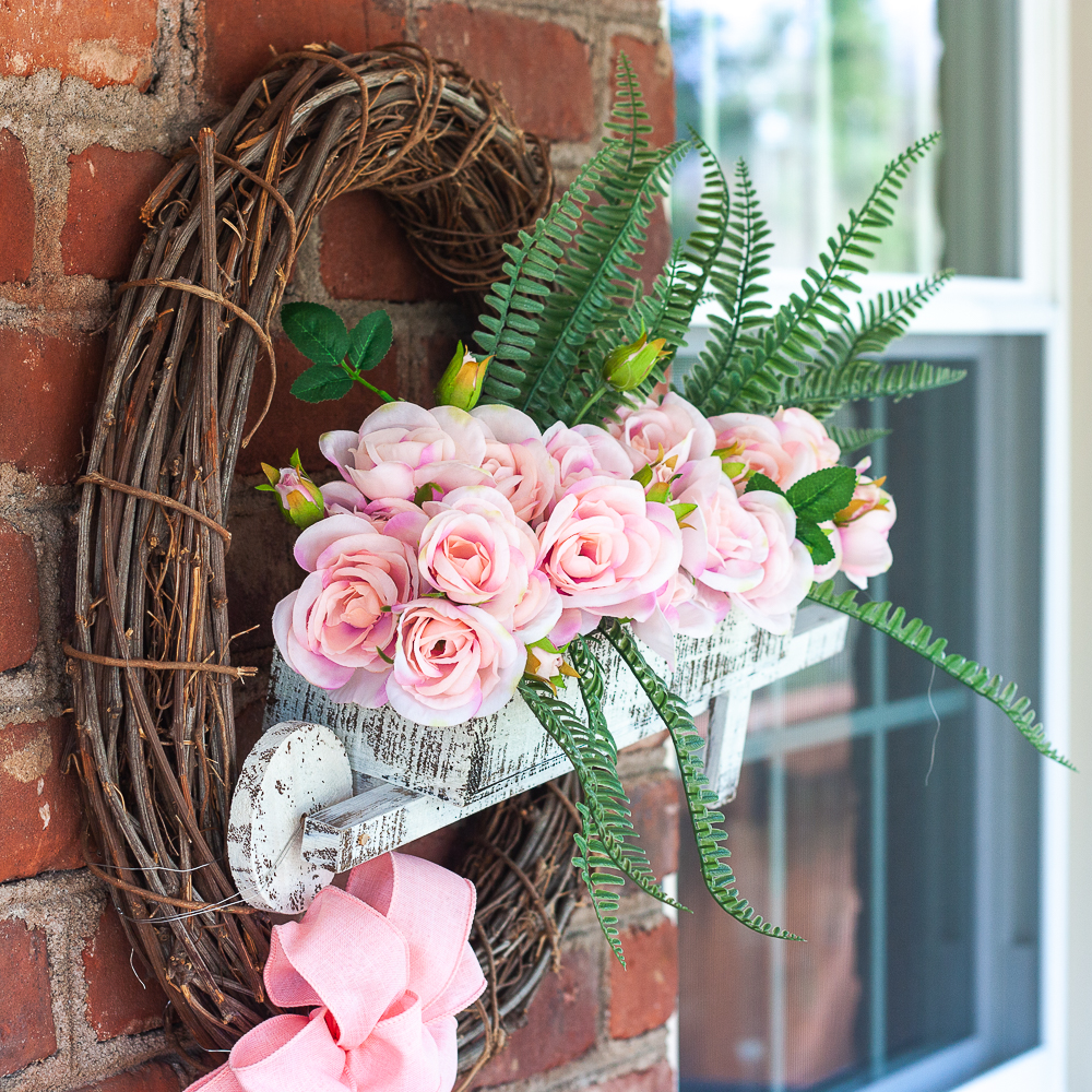 Spring wreath with a wheelbarrow filled with flowers