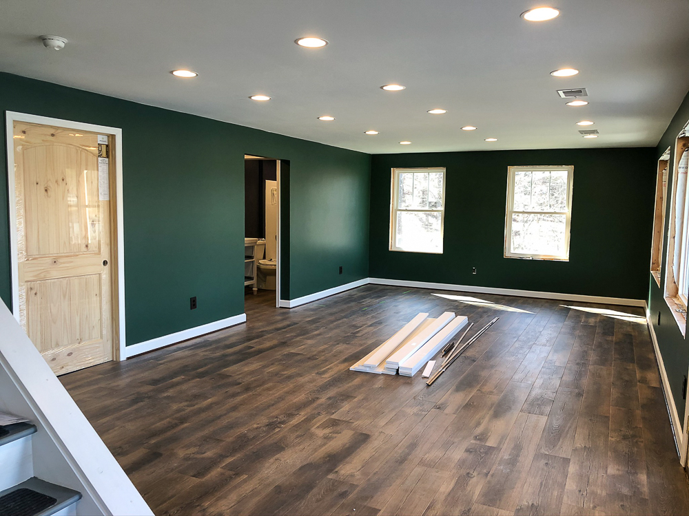 Basement with walls Painted with Sherwin Williams Emerald Paint in Rock Garden and floor installation with Mohawk Crest Loft in Prairie Oak