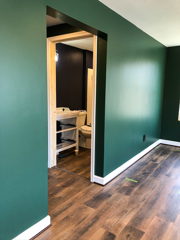 Basement with walls Painted with Sherwin Williams Emerald Paint in Rock Garden and floor installation with Mohawk Crest Loft in Prairie Oak