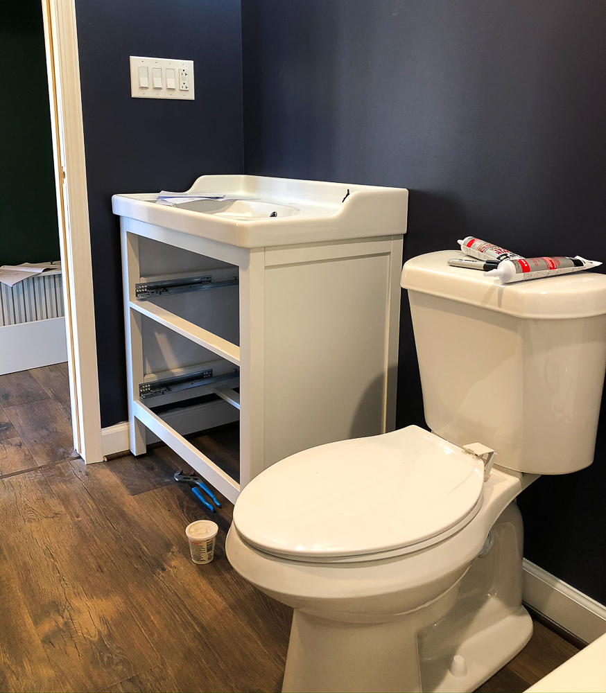 Toilet and Vanity installed in a bathroom painted with Sherwin Williams Charcoal Blue