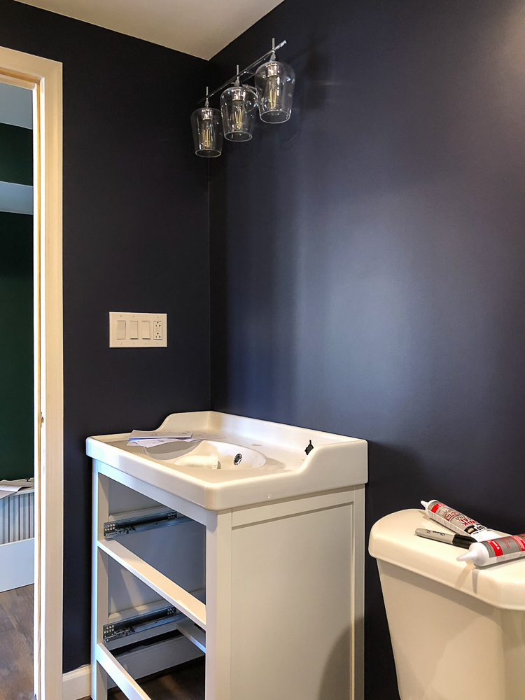 Toilet and Vanity installed in a bathroom painted with Sherwin Williams Charcoal Blue