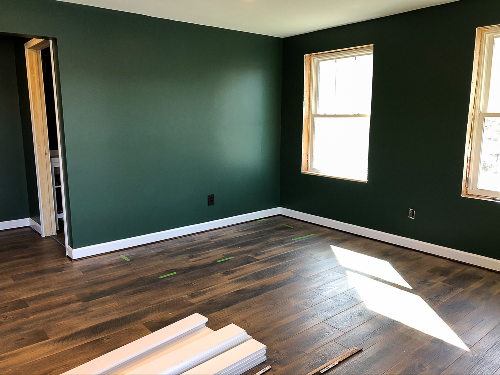 Basement with walls Painted with Sherwin Williams Emerald Paint in Rock Garden and floor installation with Mohawk Crest Loft in Prairie Oak