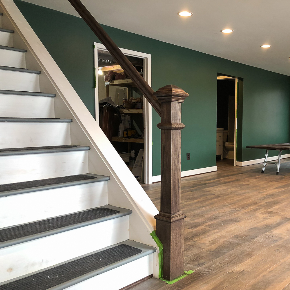 Newel post and banister installed on a set of basement stairs