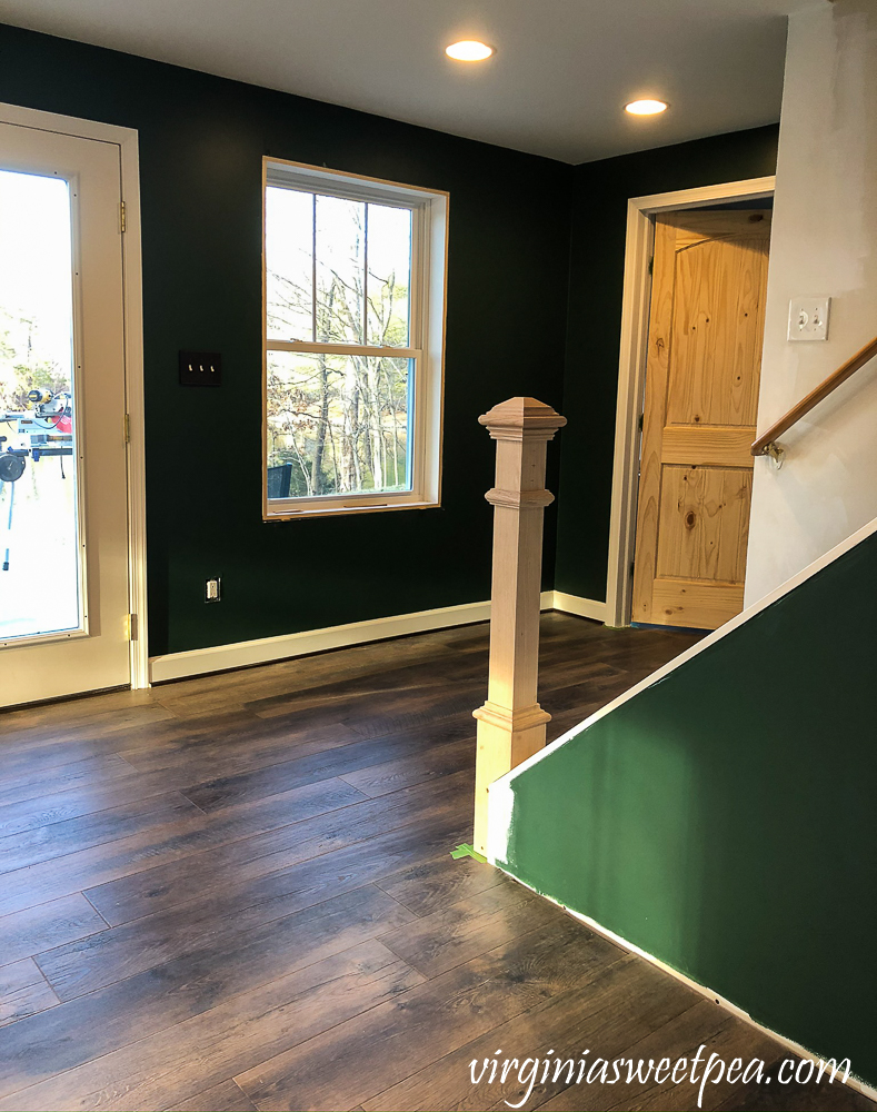 Newel post installed at the bottom of a set of stairs in a basement family room