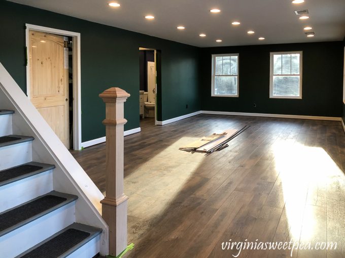 Newel post installed at the bottom of a set of stairs in a basement family room