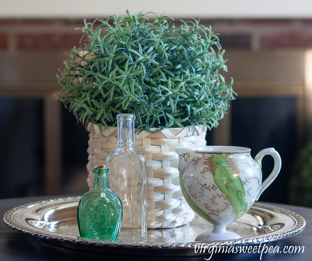 Spring Vignette with vintage bottles, vintage pitcher, and a faux rosemary plant in a basket