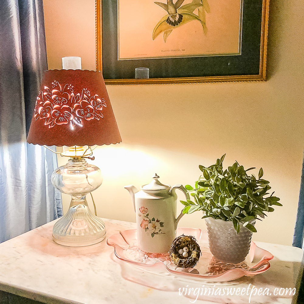 1980s lampshade with cut out flowers, pink tray with pitcher, nest, faux plant in a hobnail milk glass vase