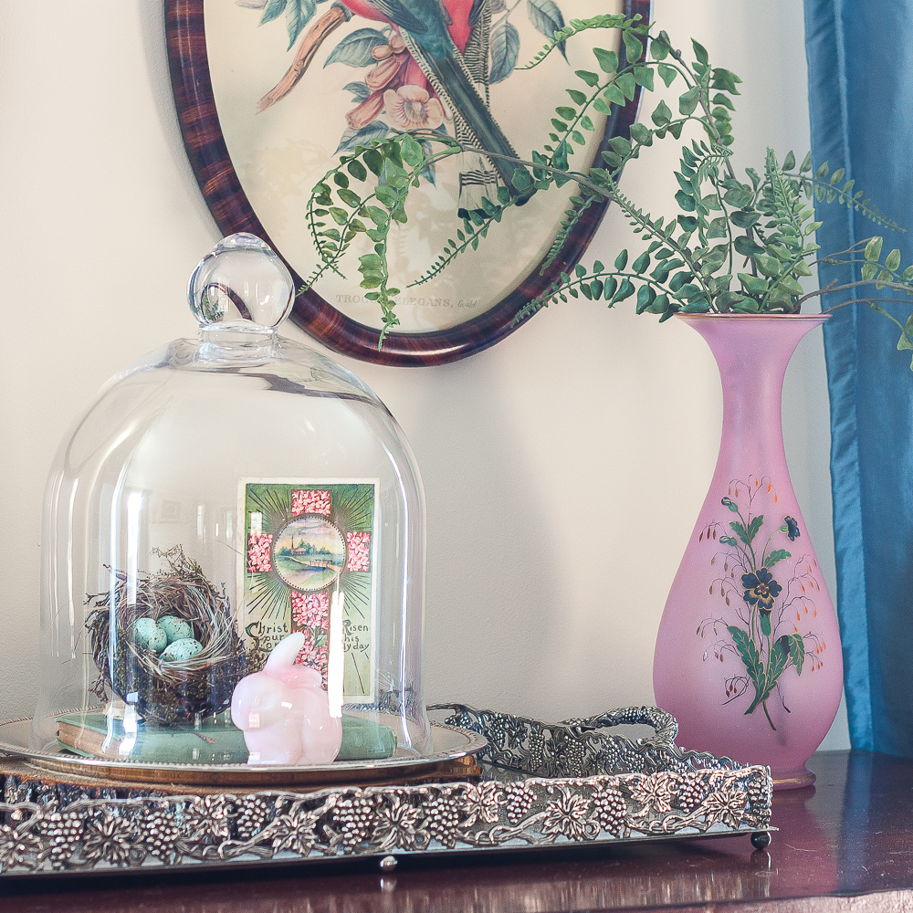 Spring Vignette with a cloche with nest, fenton rabbit and postcard, pink vase with faux ferns