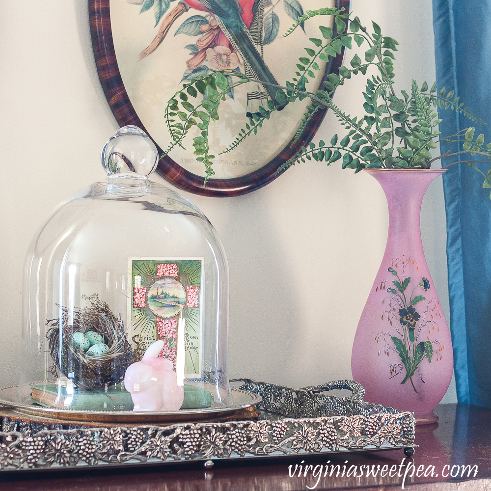 Spring Vignette with a cloche with nest, fenton rabbit and postcard, pink vase with faux ferns