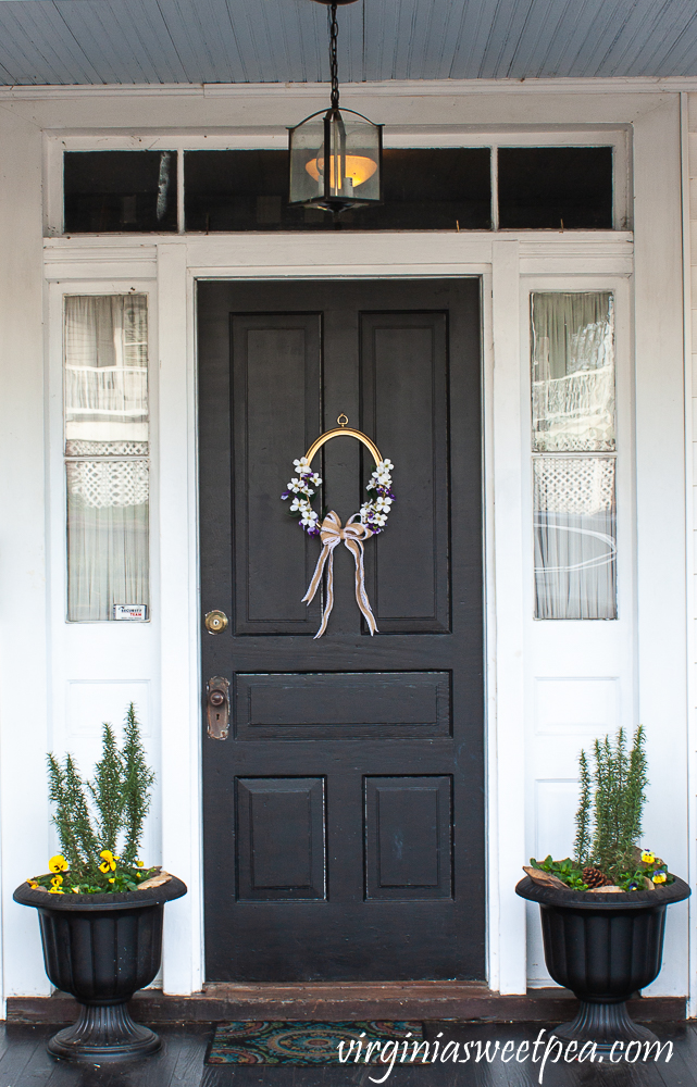 Spring wreath made from a picture frame hanging on a black door.