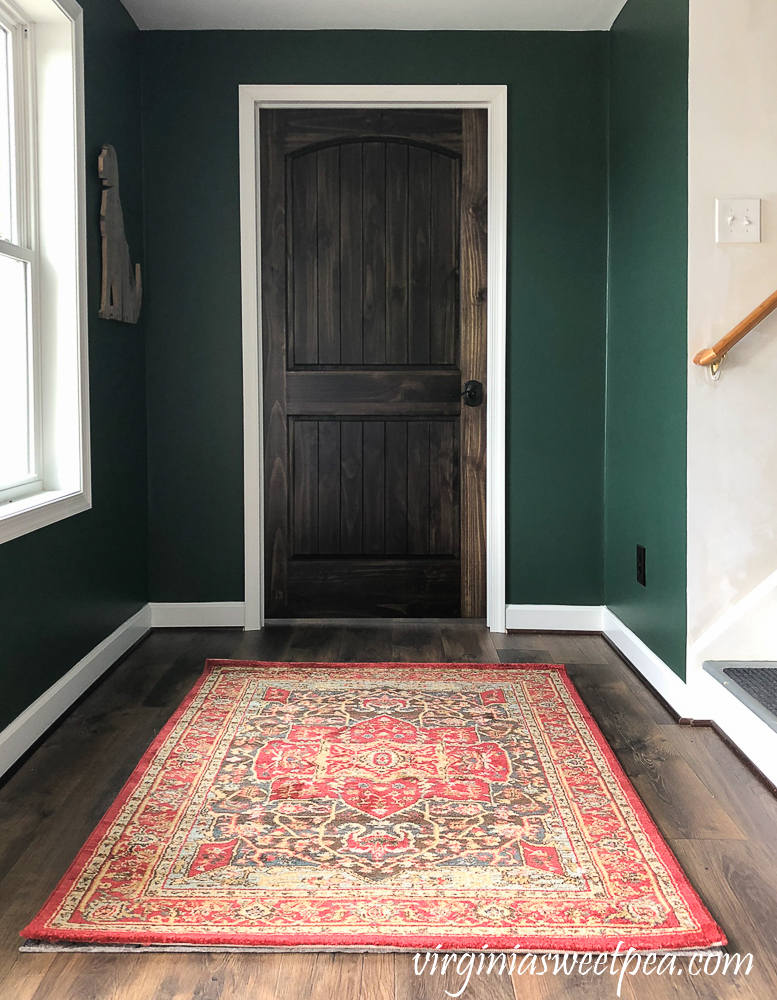 Walls painted with Sherwin Williams Emerald Paint in Rock Garden and dark stained wood door