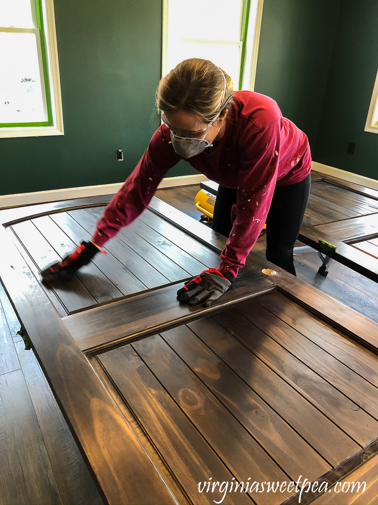 Finishing wood doors by staining and using steel wool between coats of topcoat.