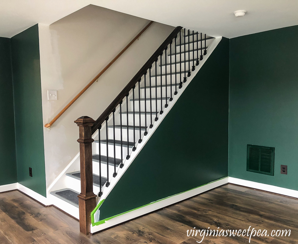 Staircase with metal balusters and wood banister and newel post.