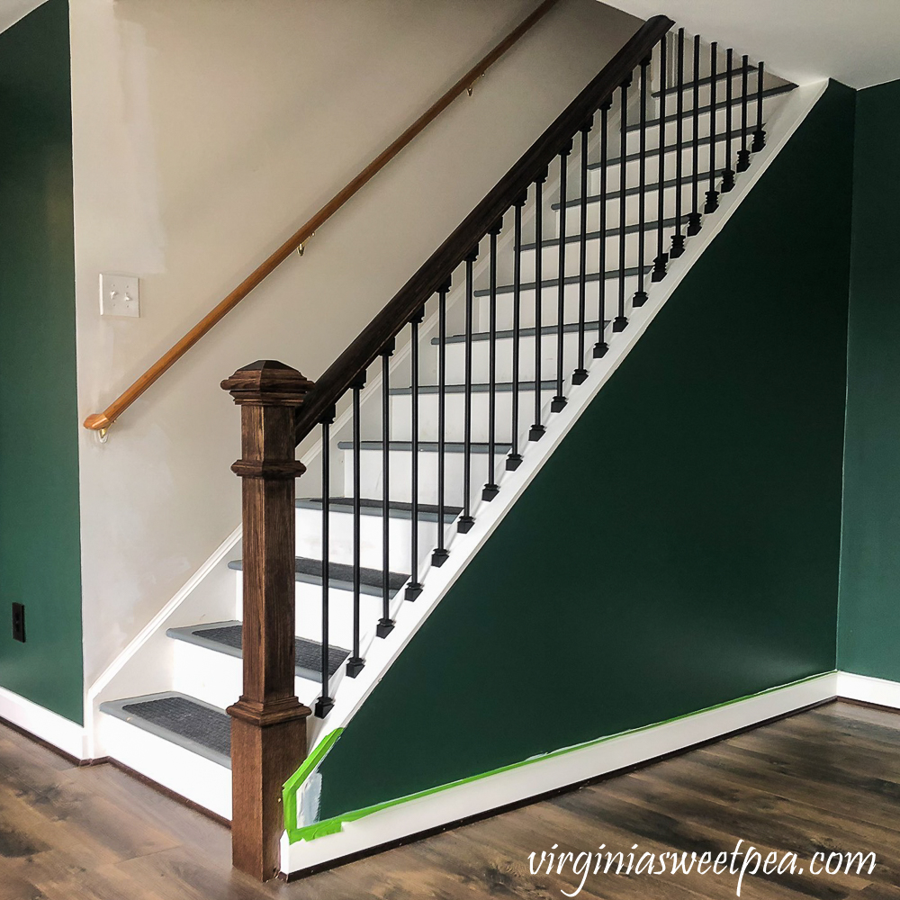 Staircase with metal balusters and wood banister and newel post.