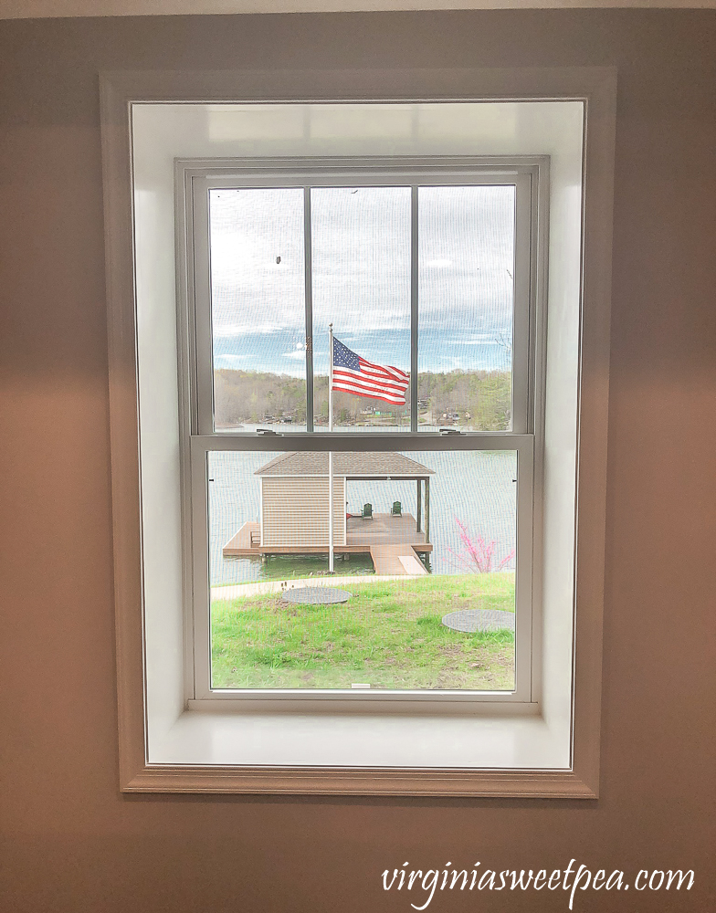 Framed window with American flag flying in the background.